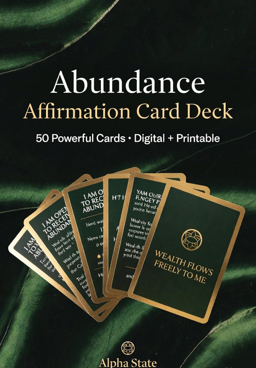 Abundance affirmation card deck with cards fanned out on a green fabric background